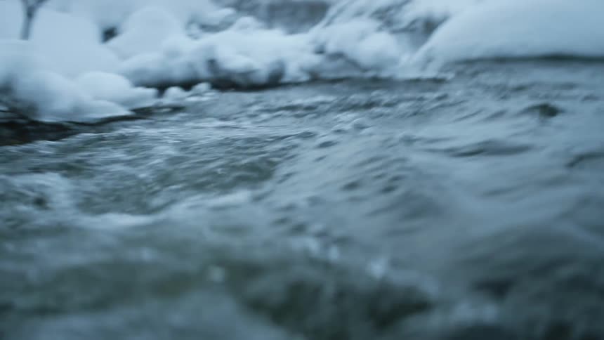 River water flowing through a snowy landscape in winter