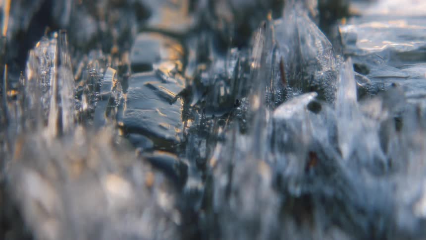 Water pools in between melting ice on the ground