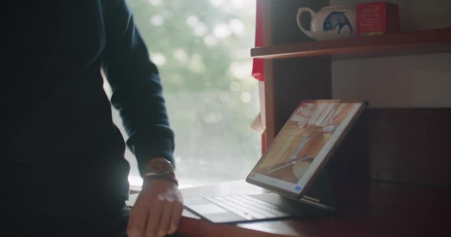 Man talking on the phone gestures over the interactive screen of a laptop