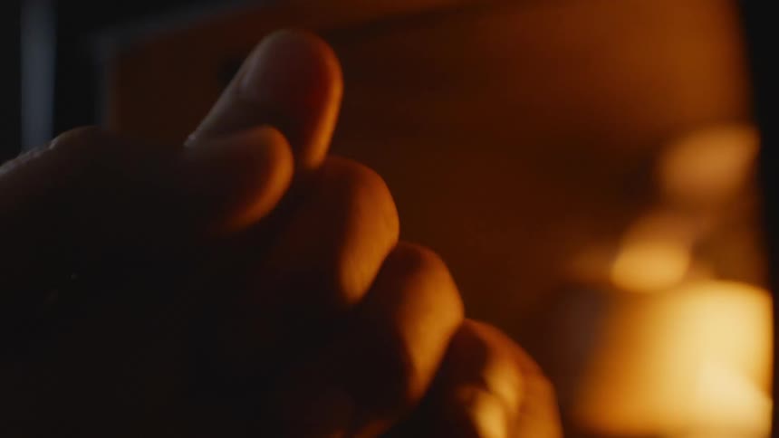 A person warming their hands by a burning fire