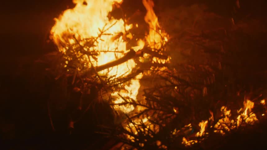 Flames on the burning brush erupt as a flammable liquid is poured on it