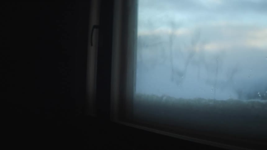 A room with flashing lights with a window with snow trees the sky and clouds in the background