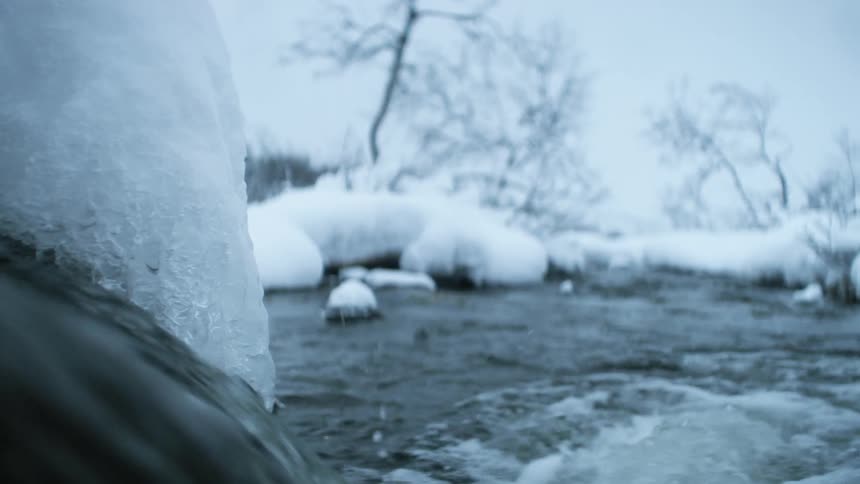 Water rushes into a partially frozen river