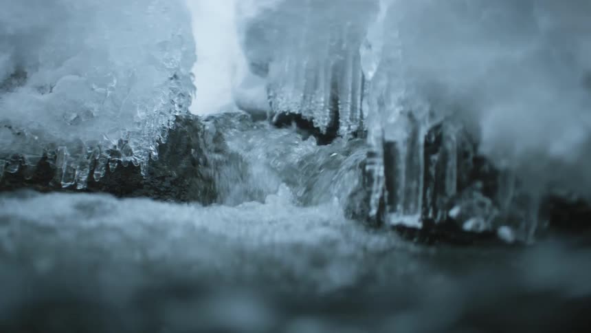 A view of water flowing down in a river in the winter