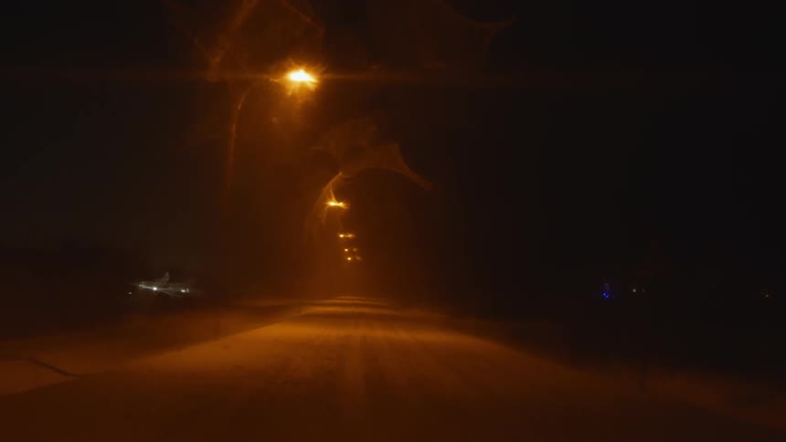 Lights moving around at the top of a light post outdoors at nighttime