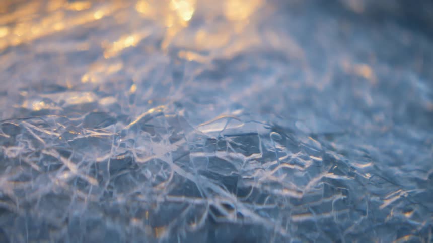 The sun shines on a frozen lake as it sets