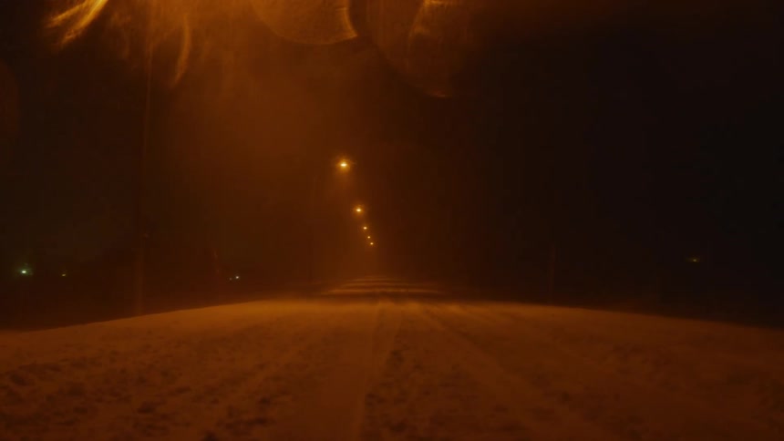 A view of a road with a lot of snow on it at night