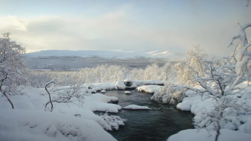 A creek runs through a snow covered field