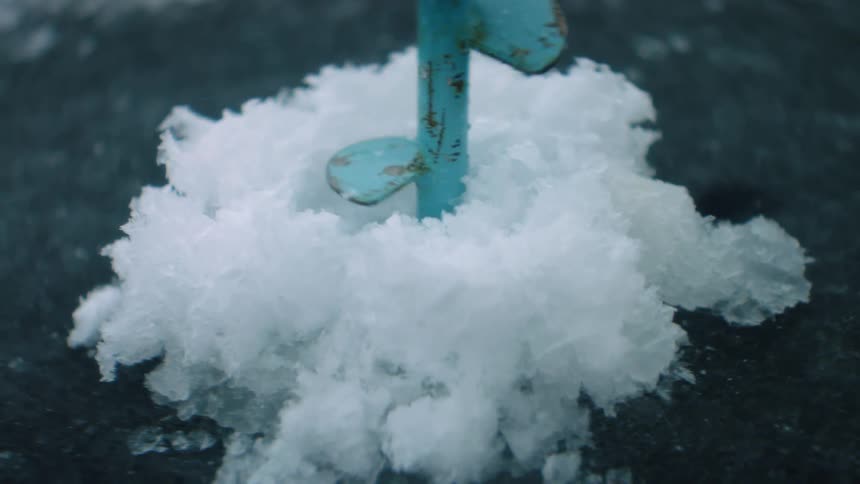 Lake water flings upward as an ice bore cuts through water