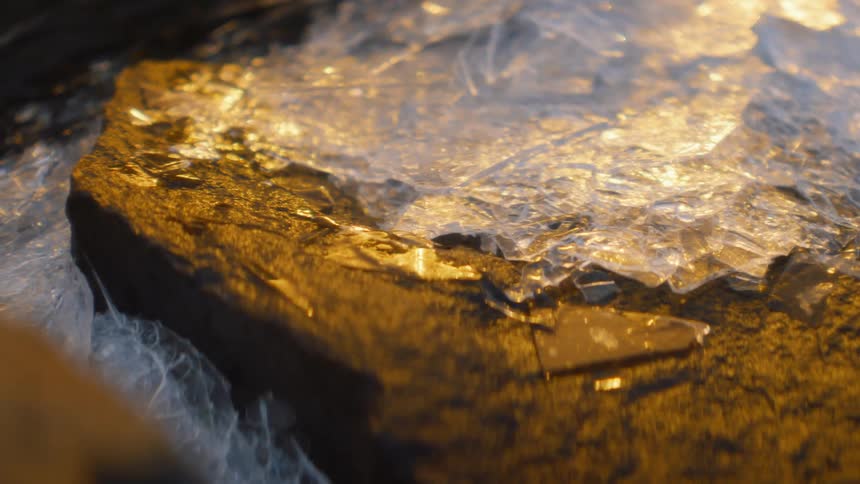 Cracked sheet of ice over a rock in the forest