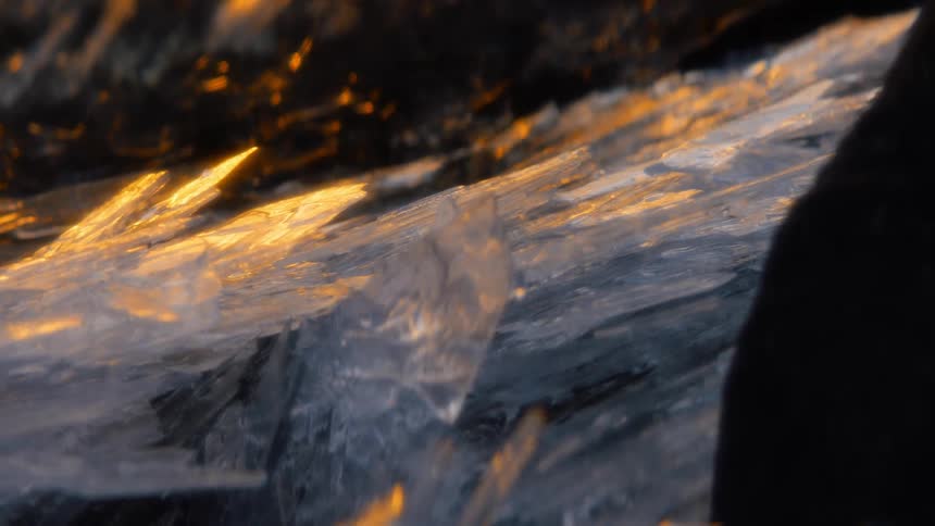 The sun sets on ice on a frozen lake