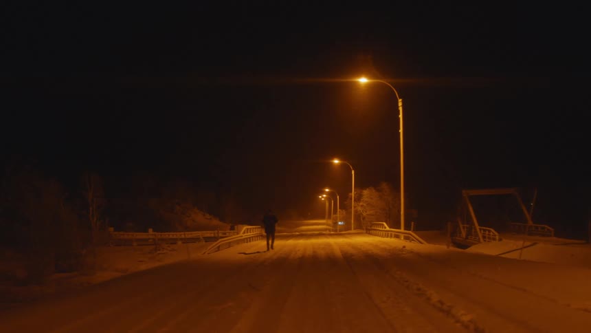 A person walking in the snow at night