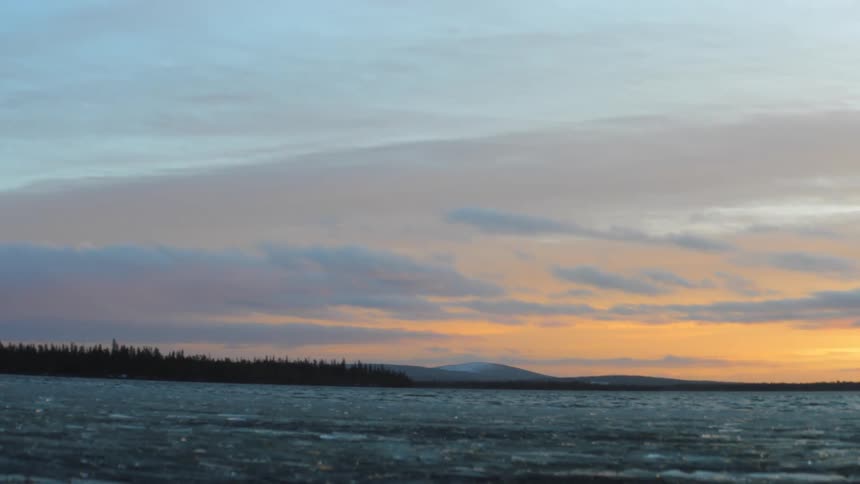The sun is rising on the lake