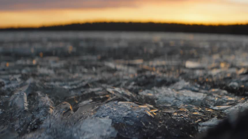 Ice covering the ground in nature at sunset