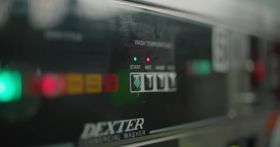 A person in a room touching the start button on a machine