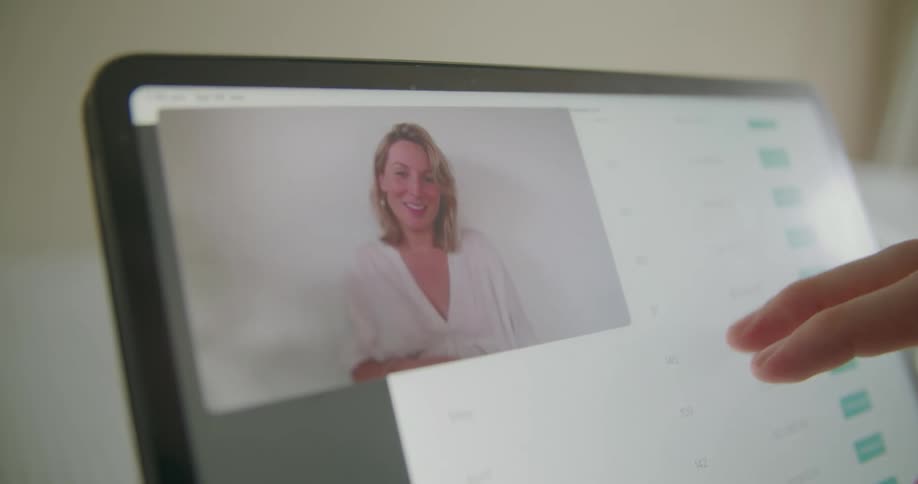 A woman talking on a video conference in a touchscreen laptop