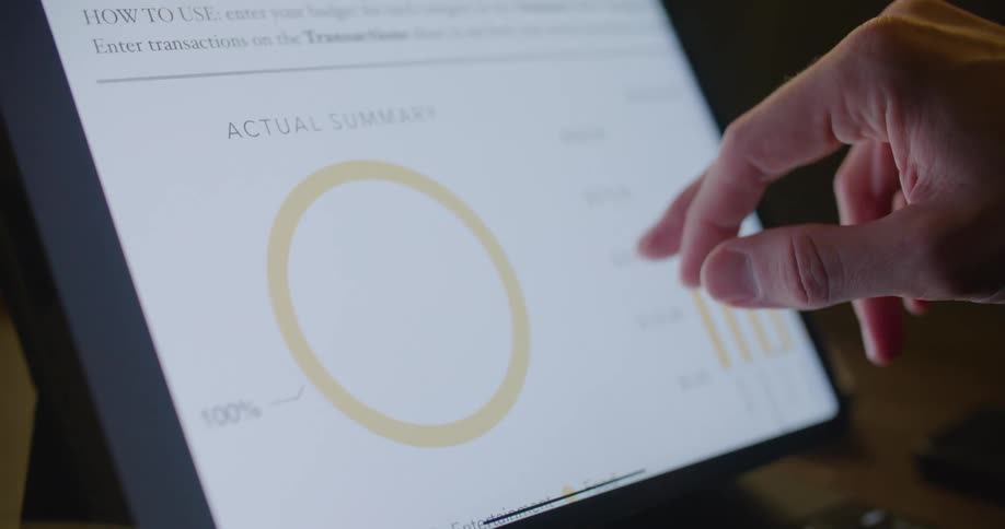 A person in an office scrolls and reads a computer screen