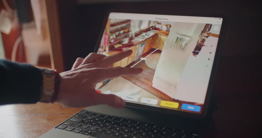 Graphics of a kitchen design is being manipulated on a laptop