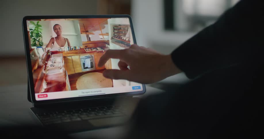 A man zooms in on a virtual design kitchen while on a video call with a woman on a laptop tablet device