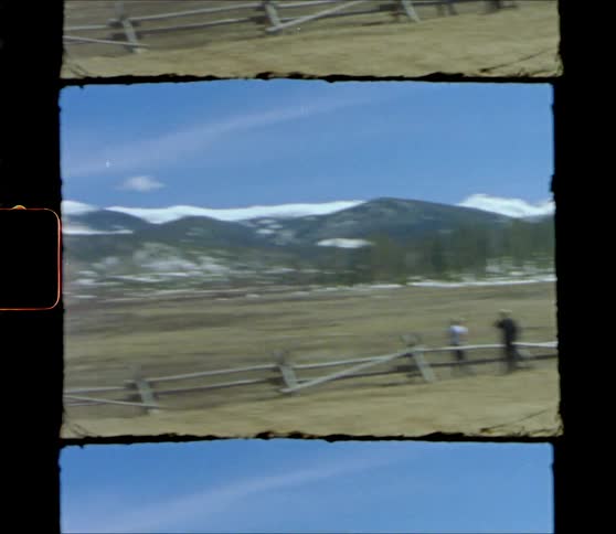 Shaky film footage of the snow covered mountain range in the countryside