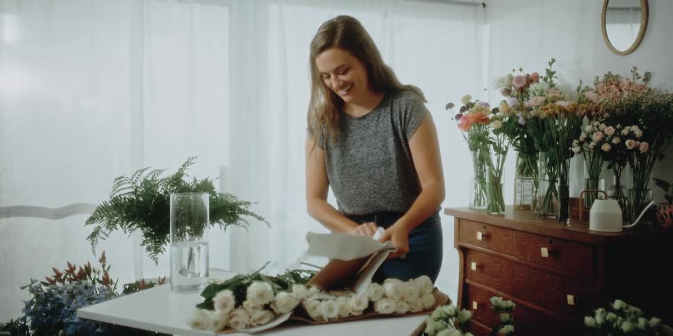 A female florist making flower arrangements indoors