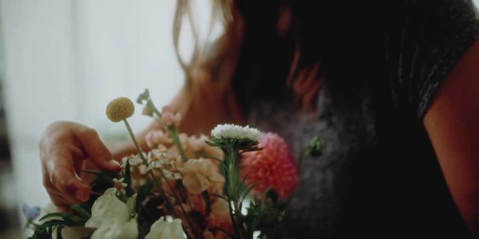Woman arranges the flowers in a bouquet