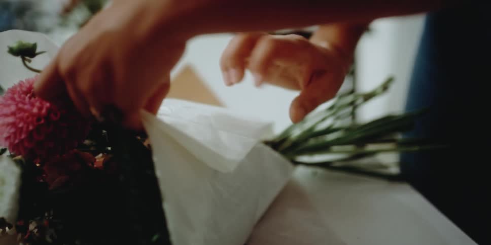 An employee wrapping flowers in a store