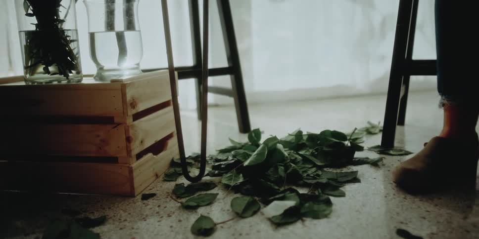 Flower leaves fall to the floor and pile up as a florist creates an arrangement