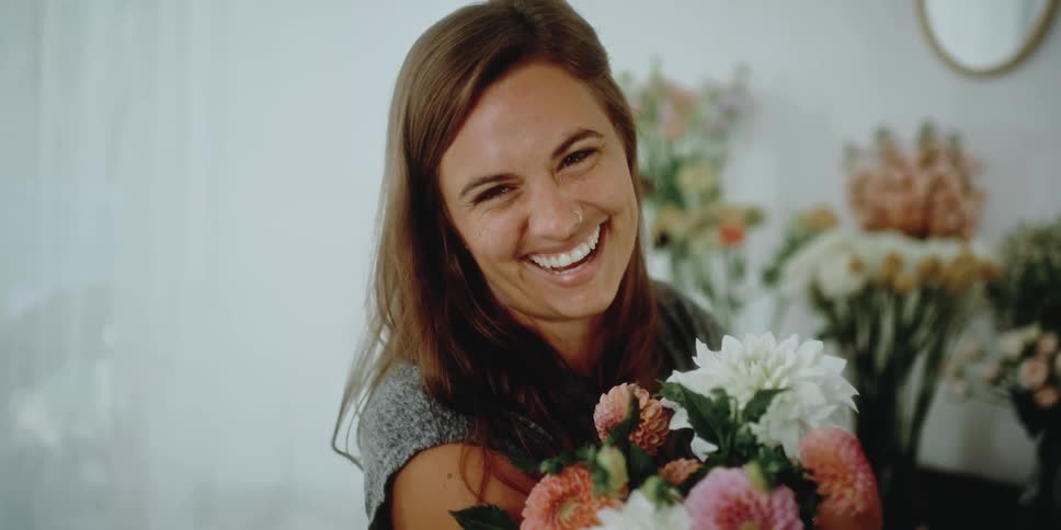 A woman smiling while holding flowers