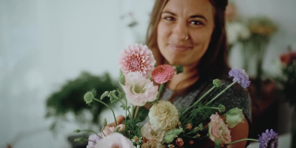 A woman smiling and holding flowers