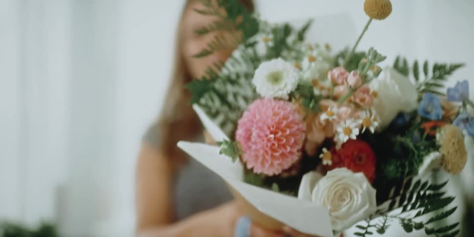 A woman picks up a bouquet of flowers