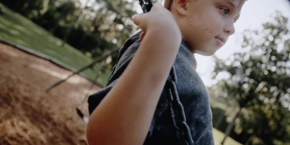 A child is on a swing at a public park