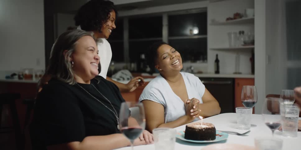 A group of friends are sitting together at a dining room table