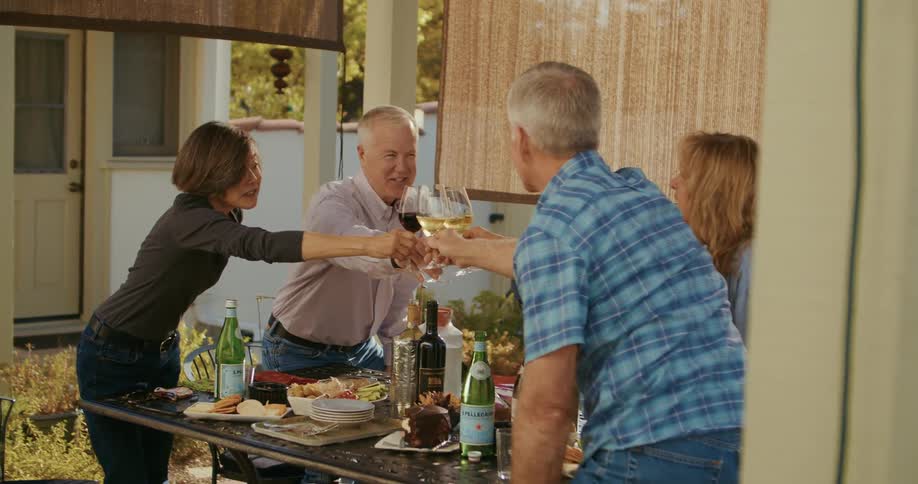 Group of friends toasting with wine over the dinner table at home