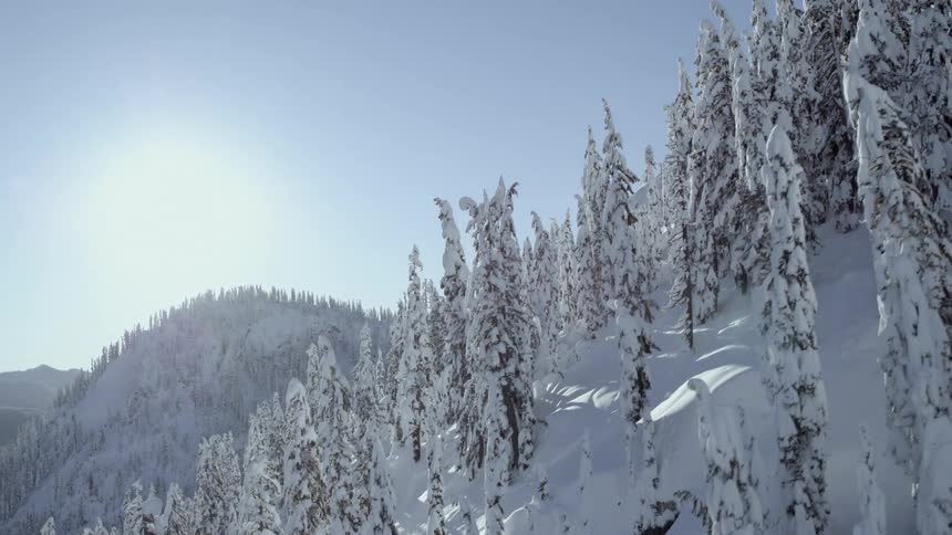 Ascending along a steep and sun kissed mountain slope covered with a blanket of fresh snow