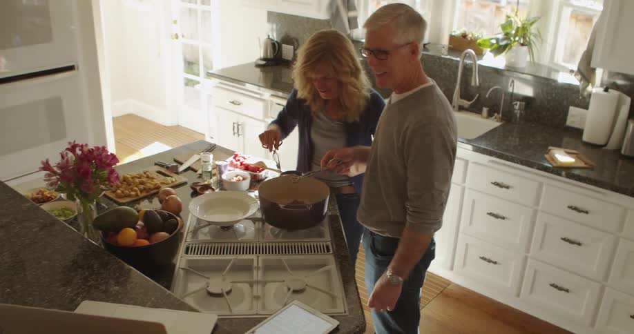 Husband and wife are cooking in their kitchen