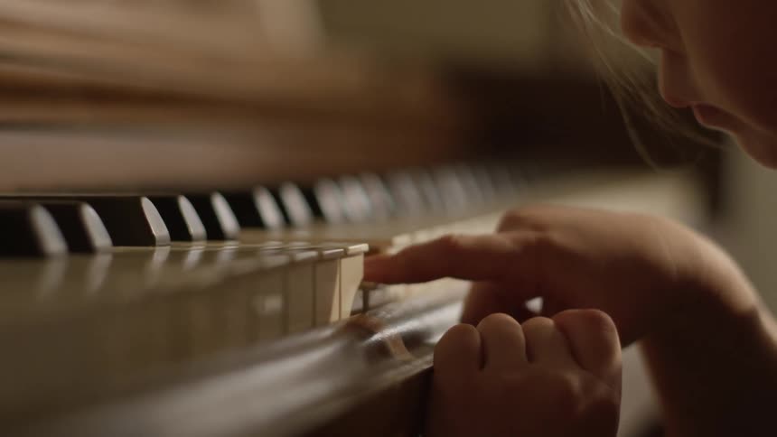 Girl pressing piano keys with a finger