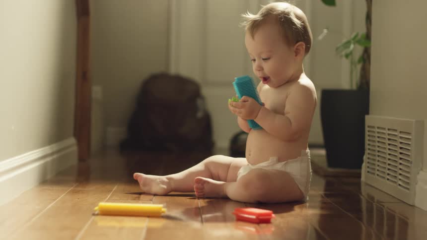 Toddler playing with colorful plastic blocks in the floor at home