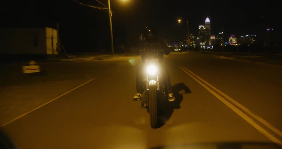 A man is riding a motorcycle at night