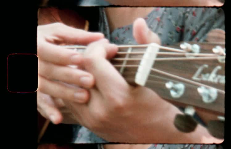 A woman teaching a man how to play a guitar