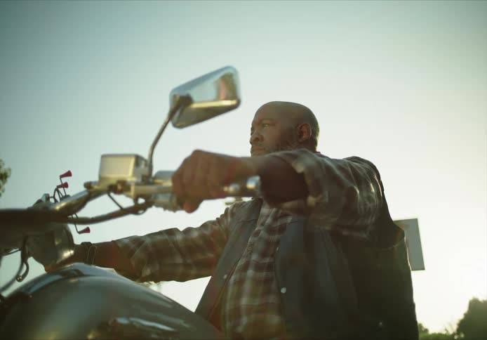 A man is sitting on a parked motorcycle
