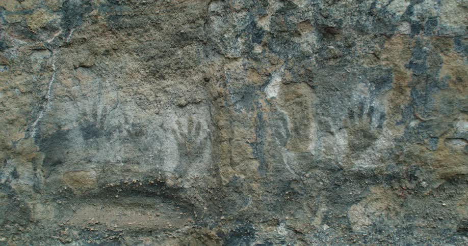 Hand prints imprinted on the large rock