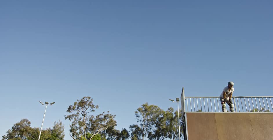 A man standing at the top of a halfpipe