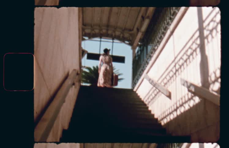 A woman quickly disappears from the top of a subway entrance