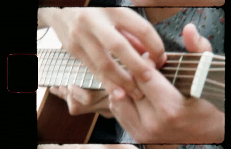 A woman teaching a man how to play a guitar
