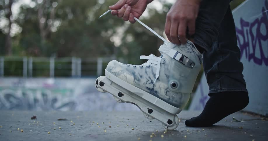 A man is tying his roller blades outdoors in spring