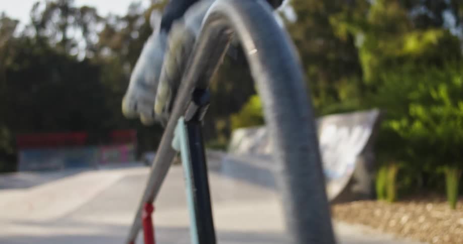 A person roller blades down a hand rail in a park