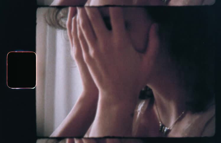 Woman covers face crying before bending head and clasping knees