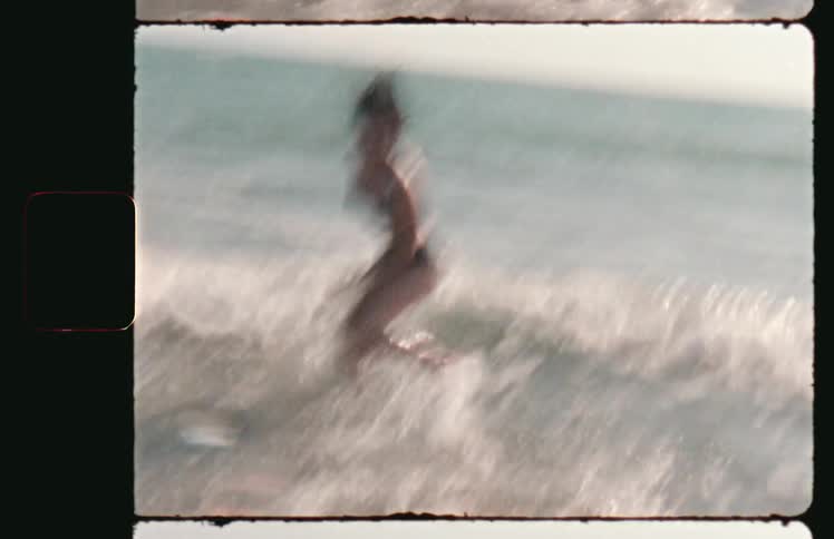 A woman running into the ocean in the middle of the day