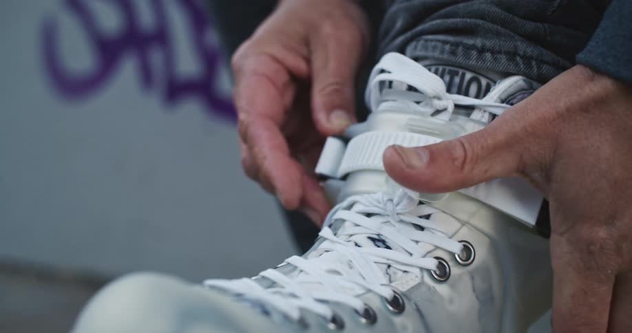 A man is putting on a shoe while sitting down